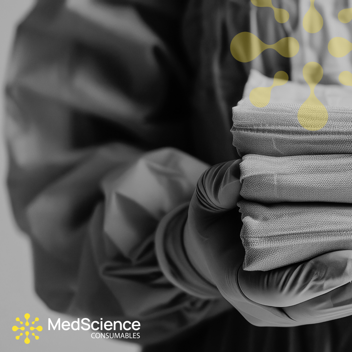 Stack of gray medical supplies with a blurred background and MedScience Consumables logo.