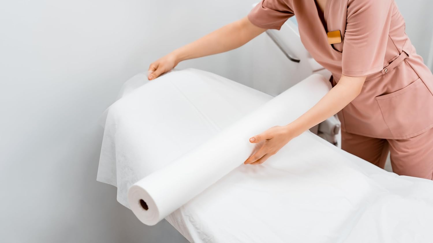 Person holding a large roll of white paper against a light gray background