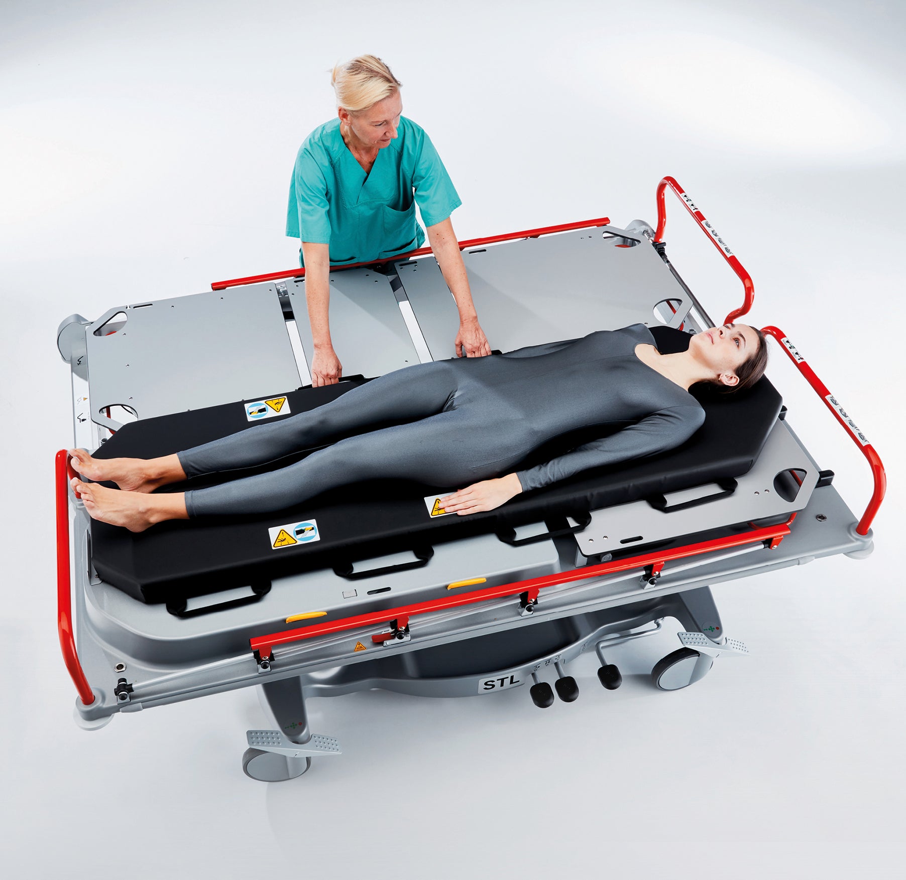 Person using a medical stretcher with a person lying on it, on a white background